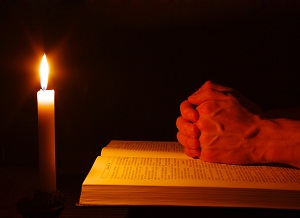 Praying-by-candle-with-bible-CONFESSION-re-sized